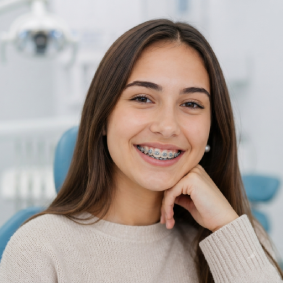 Paciente joven sonriendo con brackets